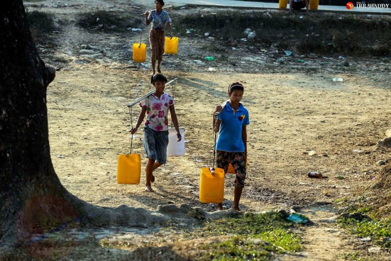 Transporting water buckets in Dala. Photo by Pyay Kyaw / The Irrawaddy
