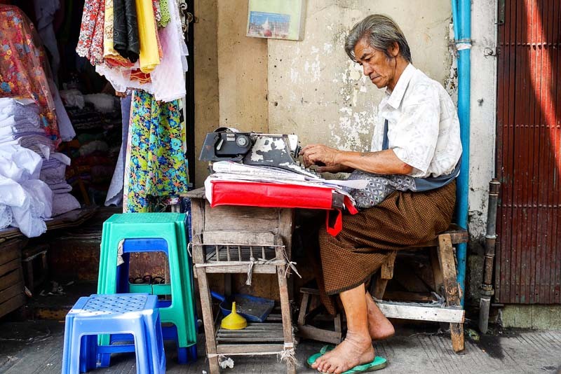 On downtown Yangon’s Pansodan Street, a typist fills out legal documents from his sidewalk station. (Photo and caption: Tin Htet Paing / The Irrawaddy)