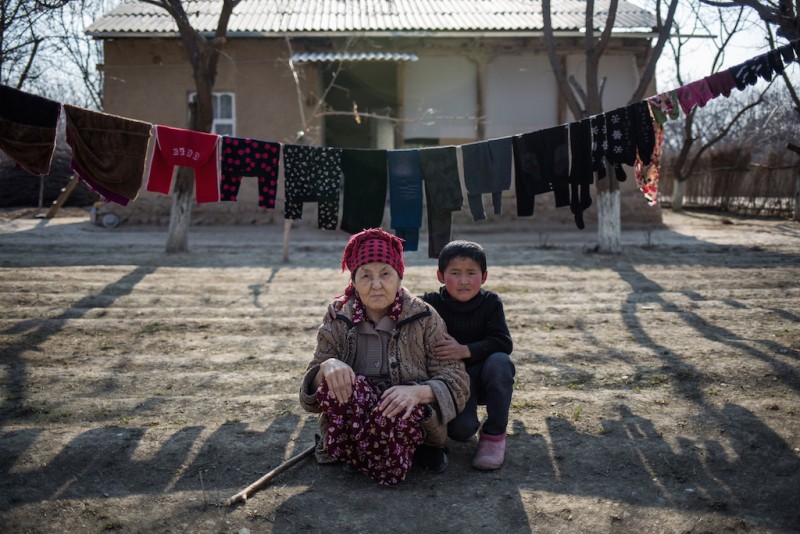  Sixty-year-old Ainysa and her grandson. All of her children work in Russia. Chek village, Batken oblast, Kyrgyzstan.