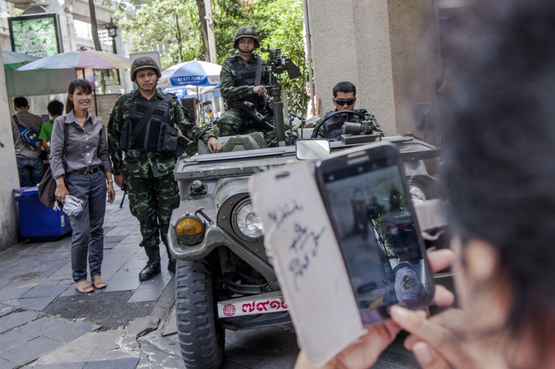 A Bangkok resident poses for a photograph with Thai soldiers. Photo by Vinai Dithajohn, Copyright @Demotix (5/20/2014)