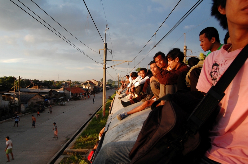 Train passengers in Jakarta sit on the roof carriage, side windows and between carriages. Photo by wisnu agung prasetyo, Copyright @Demotix, (9/29/2010)