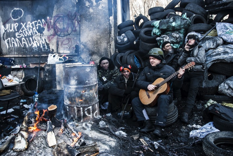 Euromaidan protesters sing songs as they warm by the fire barrels near the barricades on Hrushevskoho Street in Kiev, Ukraine on 2 February, 2014. Copyright Demotix