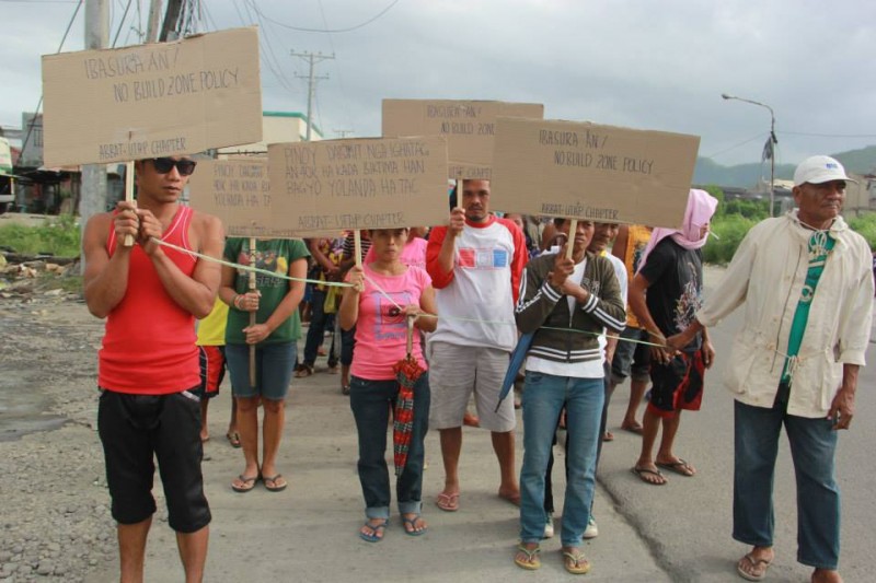 Des habitants manifestent leur opposition à la politique de zones non-constructibles à l'aide de pancartes improvisées. Photo par  Tudla