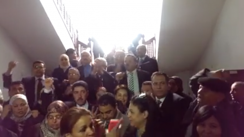 Tunisian MPs sing the national anthem during parliament lock down. [Screen shot of the video as Facebook's video embed feature messes up the post]