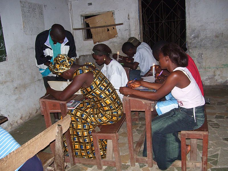 Students in Bong County, Liberia, study by candlelight. These students missed school during Liberia's civil war. Public Domain photo by United States Agency for International Development (USAID).