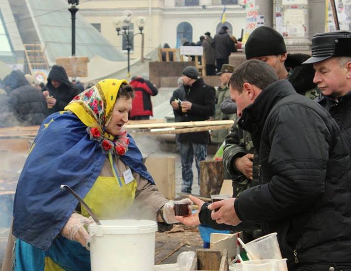 An elderly woman pouring hot tea to protesters. Photo by Olha Harbovska, used with permission.