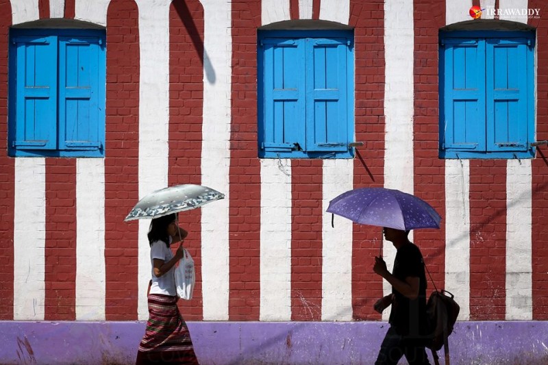 Yangon residents carry umbrella as protection from the heat of the sun. Photo by Hein Htet / The Irrawaddy