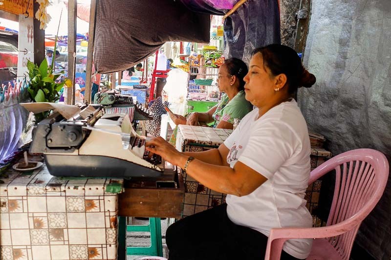 Female typists at work. While it is perceived as a field dominated by older men, The Irrawaddy found both men and women of varying ages typing up documents in streetside booths. (Photo and caption: Tin Htet Paing / The Irrawaddy)