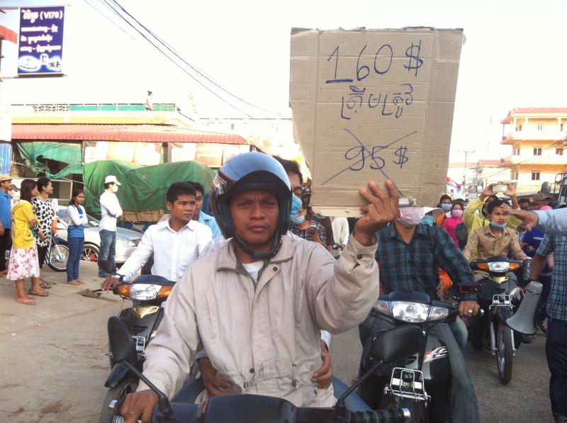 A worker holding a sign calling for a $160 dollar monthly minimum wage. Photo from the blog of Mu Sochua