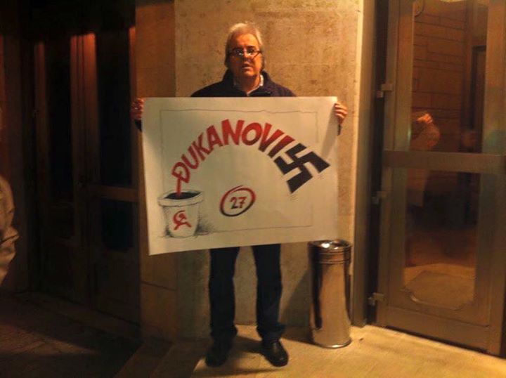 Un protestant au Monténégro tient une affiche qui symbolise la présence au pouvoir de près de 27 ans de Djukanović -- depuis ses débuts dans le parti communiste d'ex-Yougoslavie jusqu'à la mainmise qu'il a aujourd'hui sur le pays, que beaucoup ont qualifée de fasciste. 
