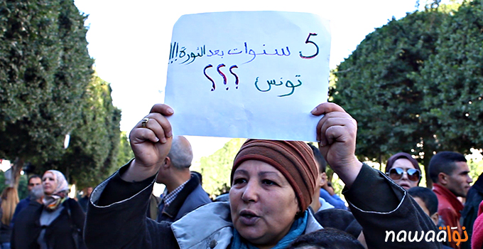 A Tunisian protester holding up a sign which reads: Five years after the revolution!!! Tunisia??? Photo credit: Nawaat