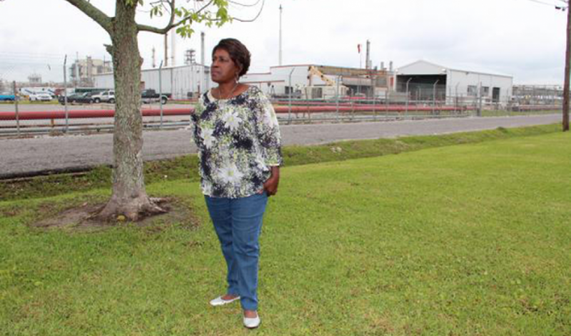 Margie Richard stands in what used to be her front yard, across the street from Shell's chemical plant in Norco, Louisiana. Richard pushed for the company to buy out the neighborhood and move residents. Credit: Reid Frazier. Published with PRI's permission.