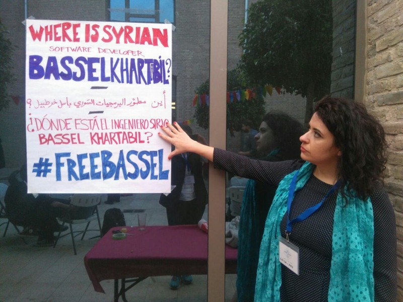 Leila señala un cartel que pide la libertad del desarrollador de software sirio, Bassel Khartabil. Foto cortesía de Leila. 