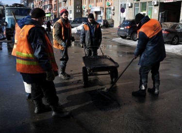 Five road workers are patching a pothole in Kyiv, Ukraine. Photo by Sergii Kharchenko, copyright © Demotix (5/02/13).