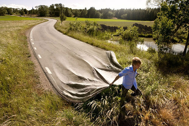 Photo montage d'un homme qui tire une route comme un drap